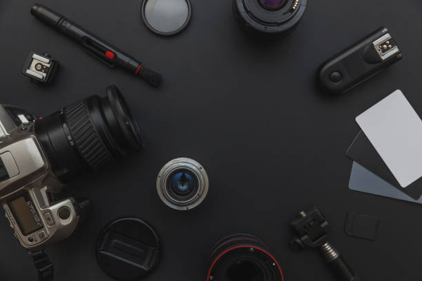 istock Photographer workplace with dslr camera system, camera cleaning kit, lens and camera accessory on dark black table background 1156519748