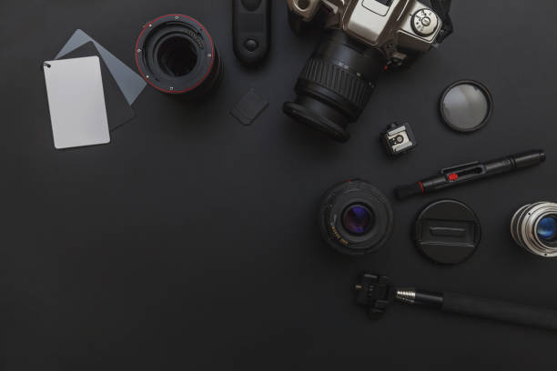 istock Photographer workplace with dslr camera system, camera cleaning kit, lens and camera accessory on dark black table background 1156519781