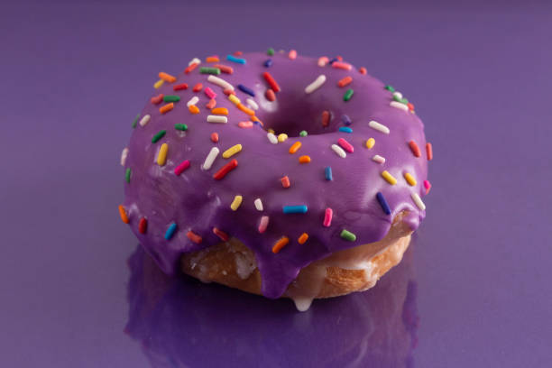 istock A Purple Glazed Donut with Rainbow Sprinkles on Top 1156521471