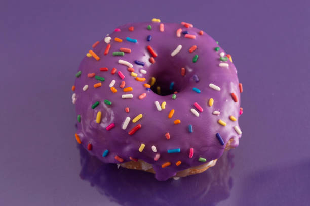 istock A Purple Glazed Donut with Rainbow Sprinkles on Top 1156522247