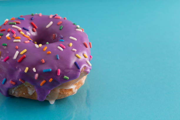 istock A Purple Glazed Donut with Rainbow Sprinkles on Top 1156522324