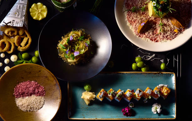 mesa de restaurante con variedad de platos de comida - sushi restaurant fish japanese culture fotografías e imágenes de stock