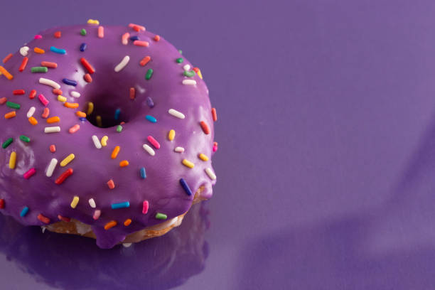 istock A Purple Glazed Donut with Rainbow Sprinkles on Top 1156522459