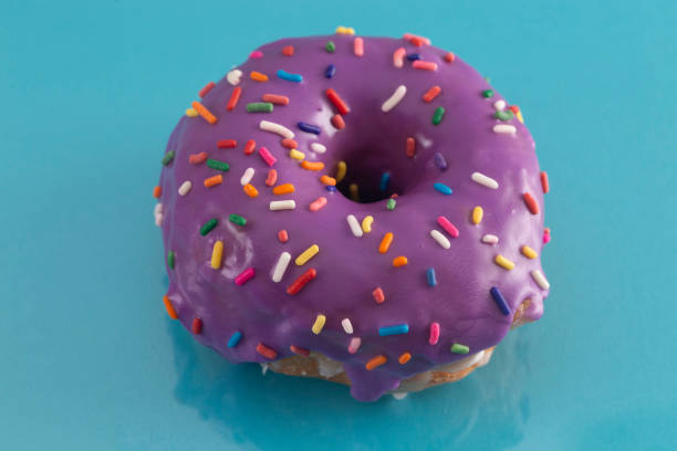 istock A Purple Glazed Donut with Rainbow Sprinkles on Top 1156522515