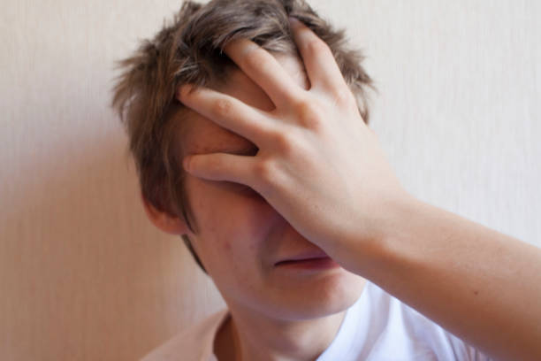 istock Teenager covers his face with his hand 1156523858