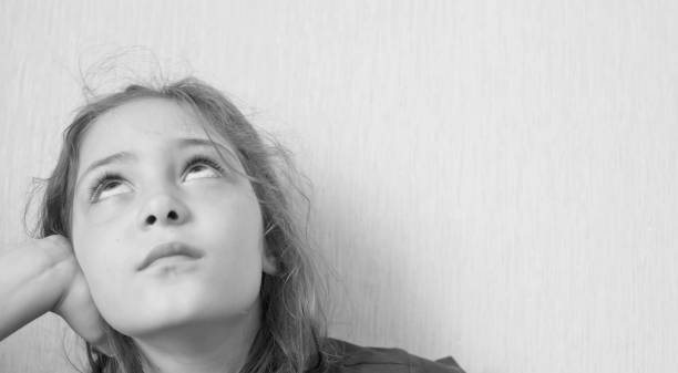 istock Little girl looking up thoughtfully 1156523918