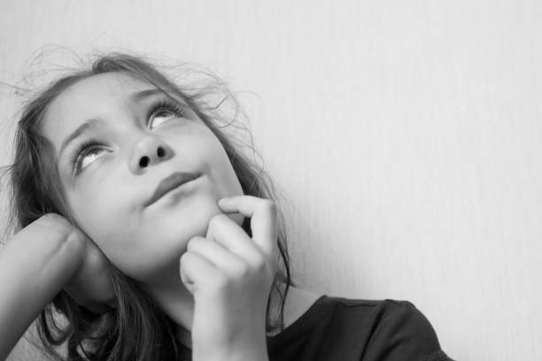 istock Little girl looking up thoughtfully 1156523976