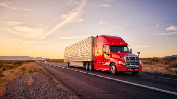 Long Haul Semi Truck On a Rural Western USA Interstate Highway Large semi truck hauling freight on the open highway in the western USA under an evening sky. haulage stock pictures, royalty-free photos & images