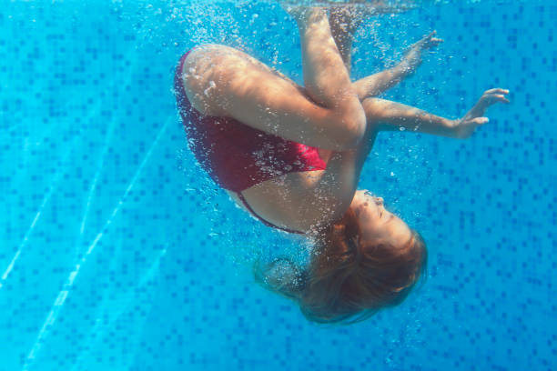 istock Little girl swimming underwater 1156528898