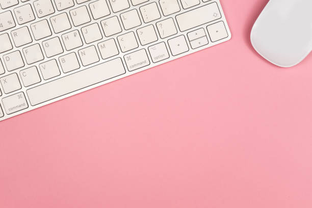 istock Pink office desk background with computer keyboard and other office supplies. Top view with copy space, flat lay. 1156530035