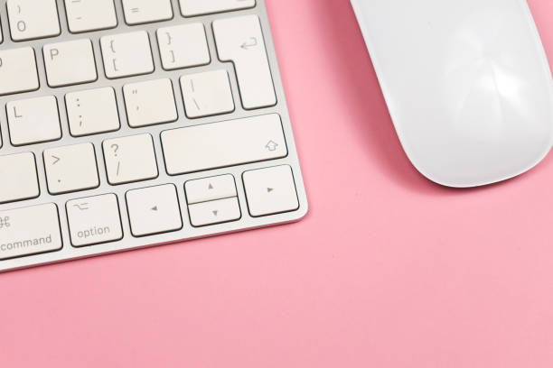 istock Pink office desk background with computer keyboard and other office supplies. Top view with copy space, flat lay. 1156530041