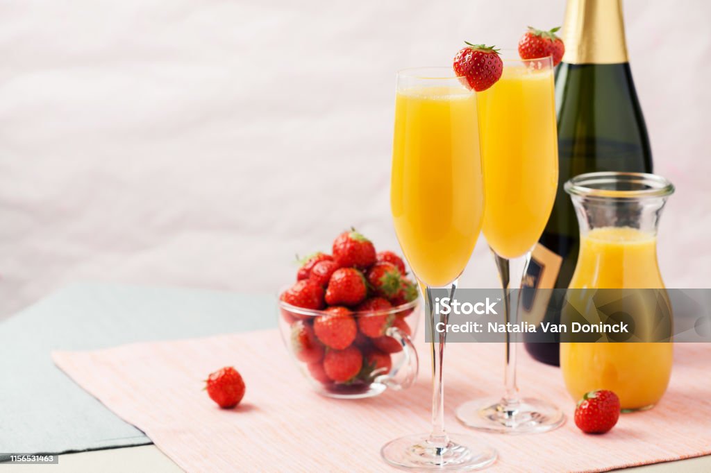 Mimosa cocktail and strawberries Two glasses of mimosa cocktail (champagne with orange juice) and fresh strawberries Mimosa Stock Photo