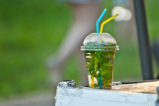 Multicolored fruit drinks close-up. Non-alcoholic drinks in plastic cups at the festival. Cocktails with juice and greens.