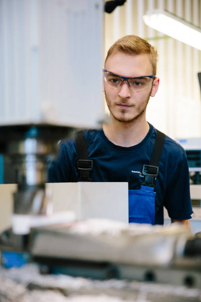 young technician works at a milling machine - trainee mechanic engineer student imagens e fotografias de stock