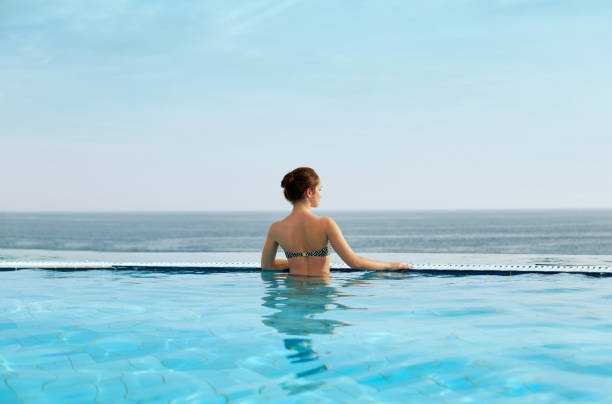 istock Woman enjoying relaxation in pool and looking 1156536405