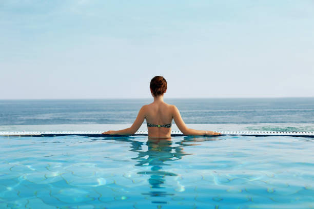 istock Woman enjoying relaxation in pool and looking 1156536410