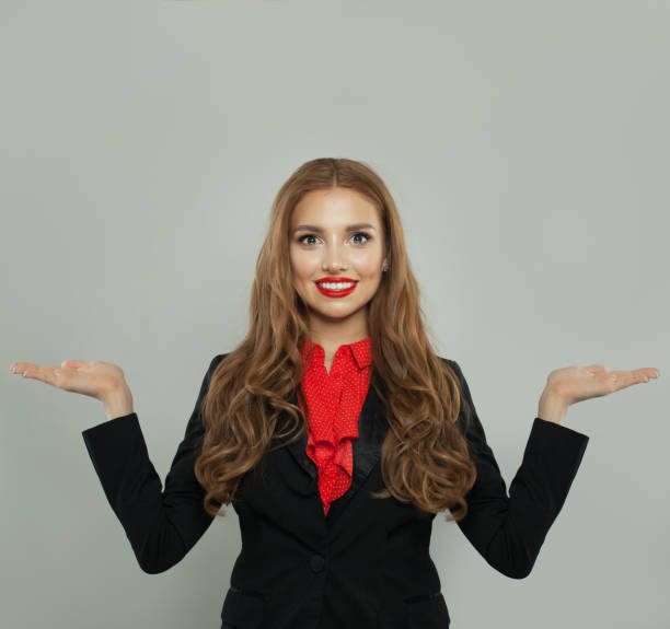 istock Successful woman holding two empty open hand on white background. Rate, weigh and represent 1156539146
