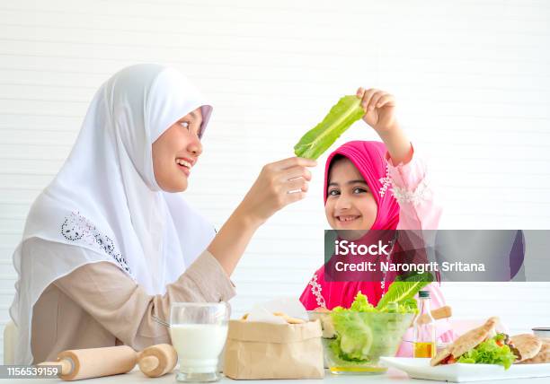 Muslim Mother Discuss And Teach About Vegetable For Food To Her Little Girl With White Background Stock Photo - Download Image Now