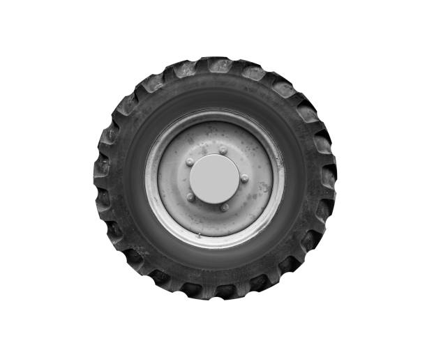 Close-up of a large yellow wheel of a tractor with black tire, agricultural machinery