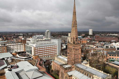 Aerial view of Coventry Cathedral and the city under clouds