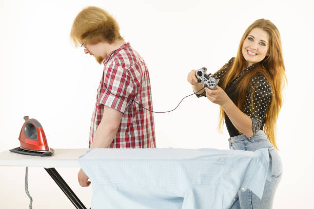 istock Woman controling man to do ironing 1156557327