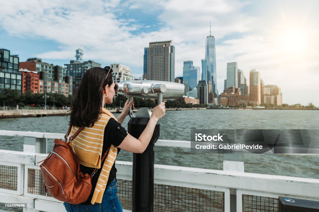 Woman traveling in New York using the tourist binoculars Adult Stock Photo