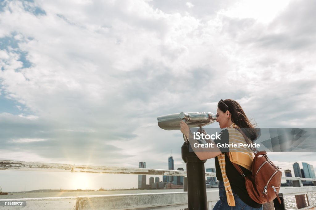 Woman traveling in New York using the tourist binoculars Adult Stock Photo