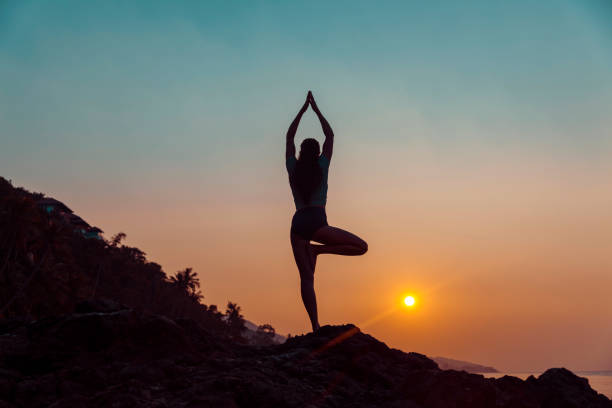 istock Woman practicing yoga on the beach 1156572826