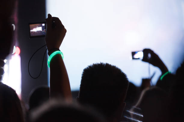 aficionados que sostienen teléfonos móviles en un concierto - applauding clapping wristband crowd fotografías e imágenes de stock