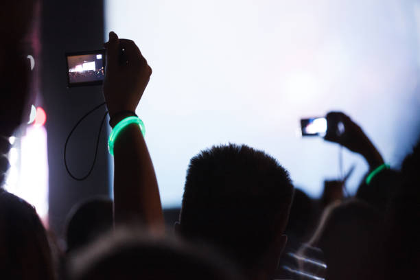istock Fans holding mobile phones at a concert 1156573897