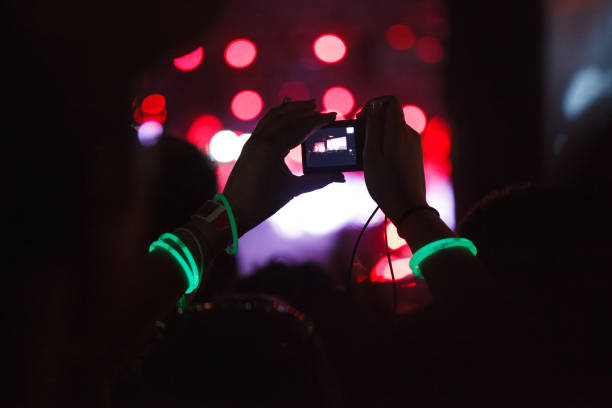 personas capturando los mejores recuerdos en un teléfono móvil durante el festival de música - applauding clapping wristband crowd fotografías e imágenes de stock