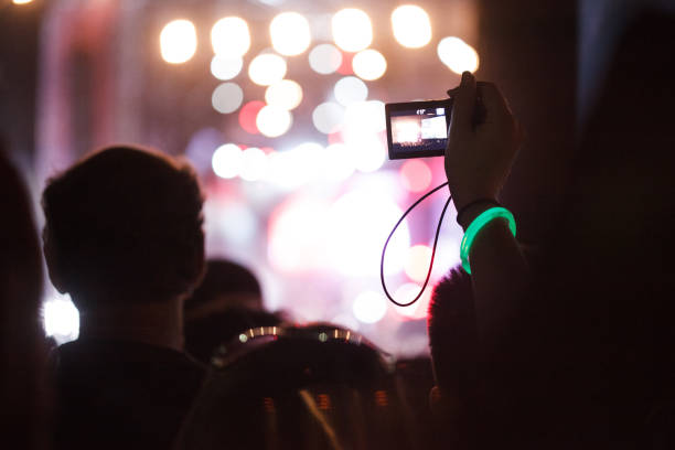 fans tomando fotos y grabando videos con teléfonos inteligentes durante el concierto en vivo - applauding clapping wristband crowd fotografías e imágenes de stock