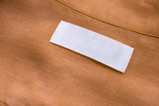 istock White blank clothing tag label on brown linen shirt fabric texture background 1156573923