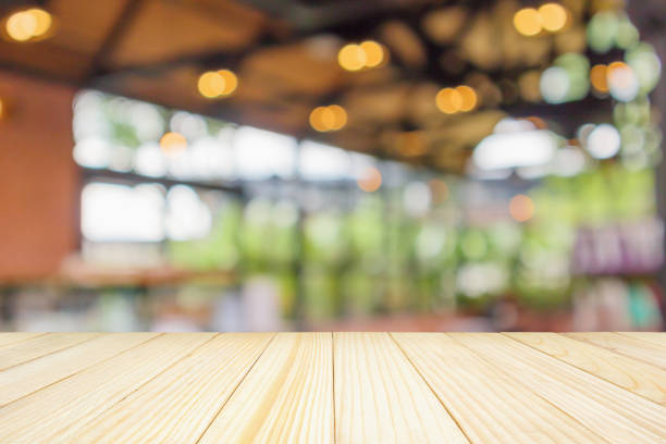 istock Empty wood table top with abstract blur coffee shop or cafe restaurant background with bokeh light for montage product display 1156574315