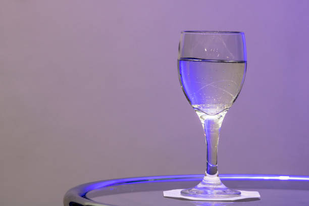 istock water in glass on the table with purple light 1156582368