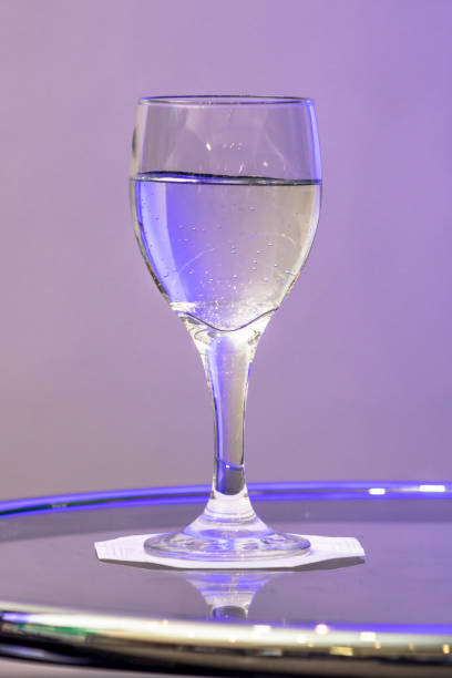 istock water in glass on the table with purple light 1156582449
