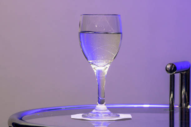 istock water in glass on the table with purple light 1156582450