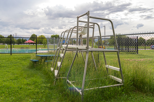 This group of old lifeguard chairs have been left outside the gates of a public swimming pool.  The chairs were once a witness to all the fun happening at the pool but now they are left abandoned to the grass and weeds.