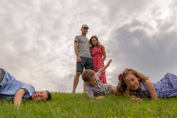 Three kids sitting on grass at Turkey resort against palms.