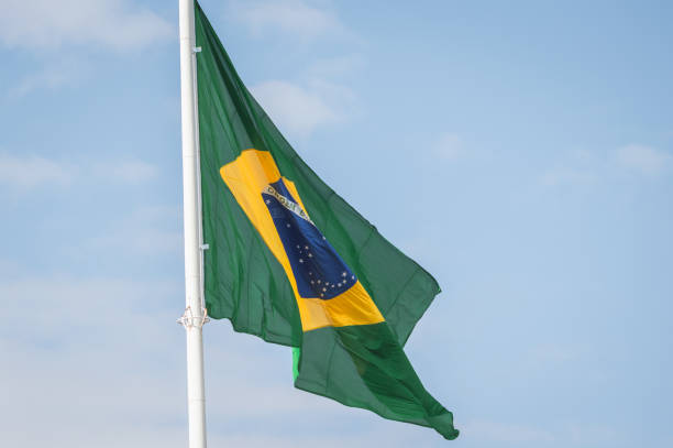 istock Brazil flag waving at the wind against blue sky 1156607967