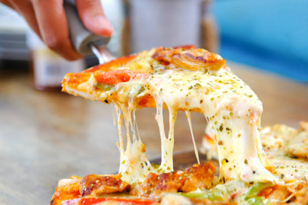 istock Chef's hands are cutting pizza with cheese. From the pizza tray 1156608233