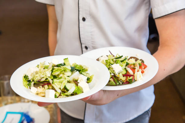 istock Waiter hold two plates of salad, work on event servi. 1156616955