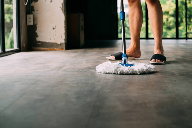 istock Man cleaning up living room using mopping tool 1156617827