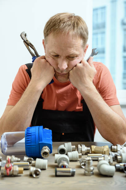 istock The worker is thinking and looking at the elements of the plumbing. 1156619053