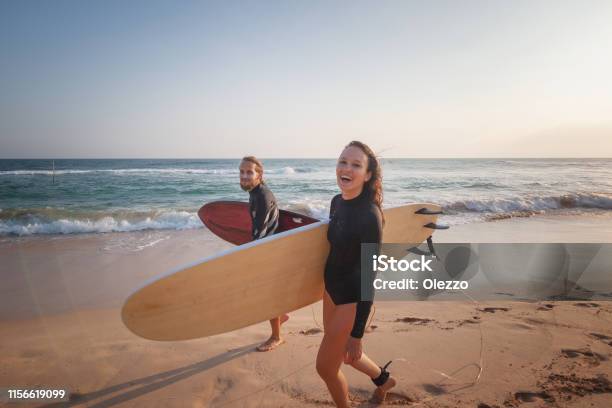 Young Couple Happy Smiling Surfers On Ocean Coast Sport Active Lifestyle Vacation Travel Concept Stock Photo - Download Image Now