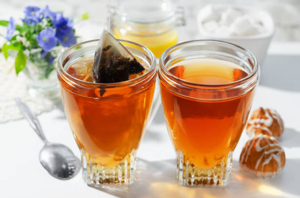 Two cups of hot tea bags, cookies and honey. The process of brewing tea. Selective focus. stock photo