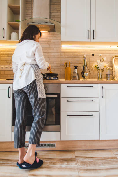 istock view from behind woman on kitchen cooking 1156624650