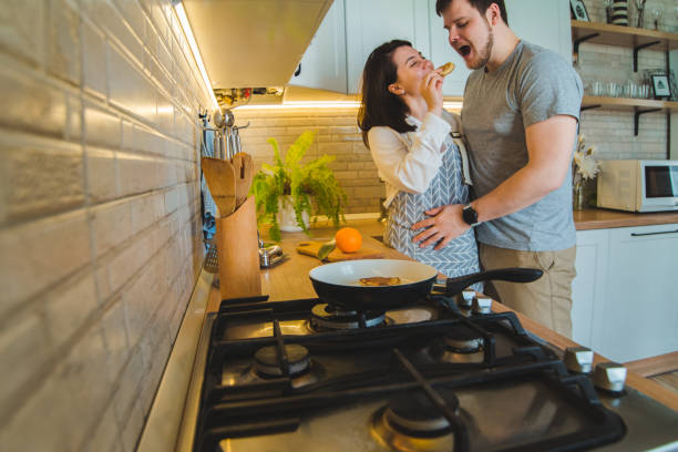 istock lovely couple hugging on the kitchen while cooking breakfast 1156624699