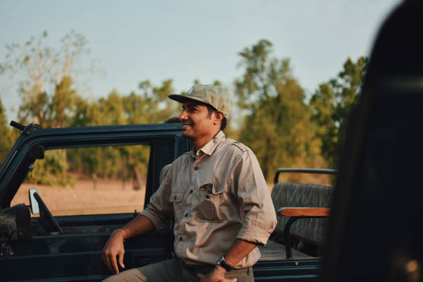 istock Man standing by the safari vehicle 1156628905