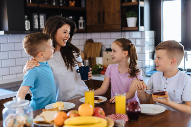 istock Mother and three kids in the kitchen eating breakfast 1156629285